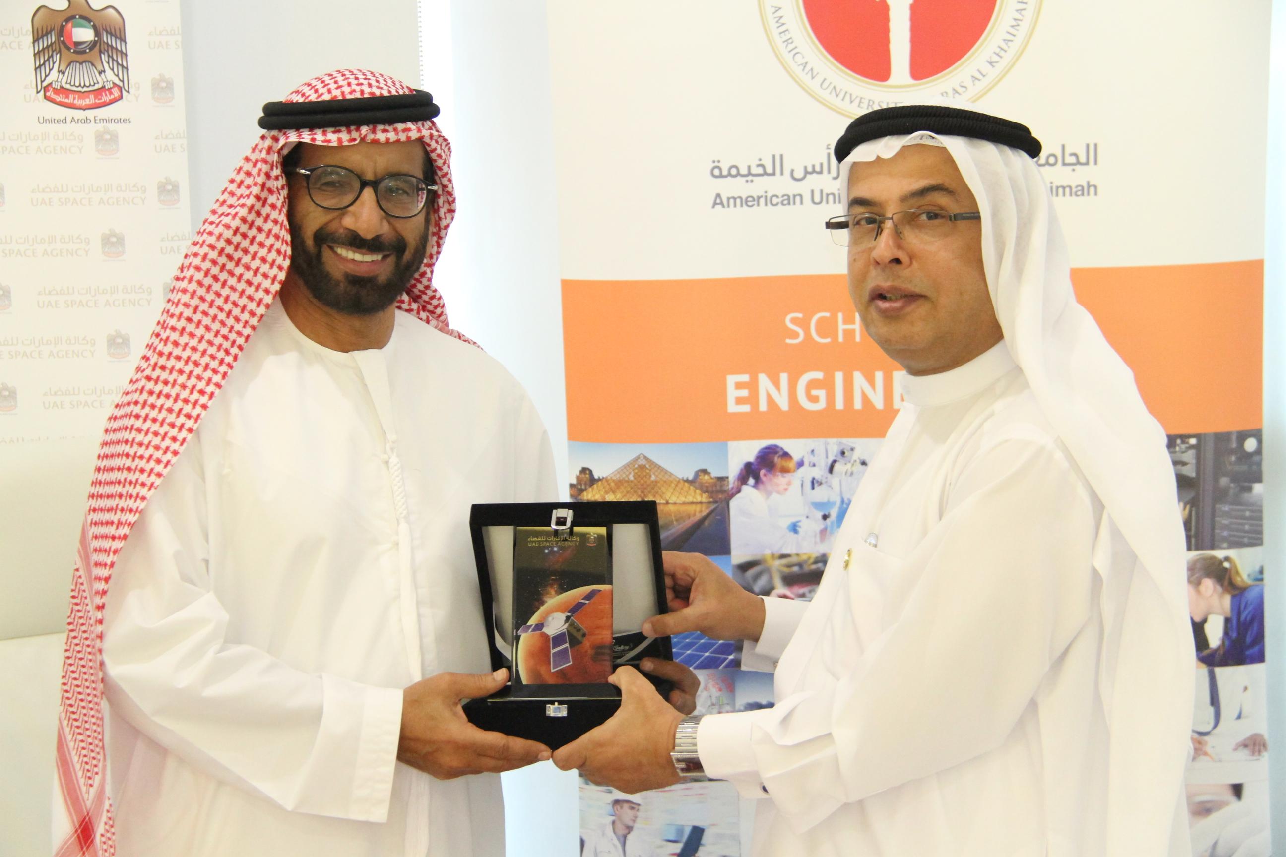 Professor Al Alkim and H. E. Dr. Al Romaithi exchange tokens of appreciation following the signing of the memorandum of understanding